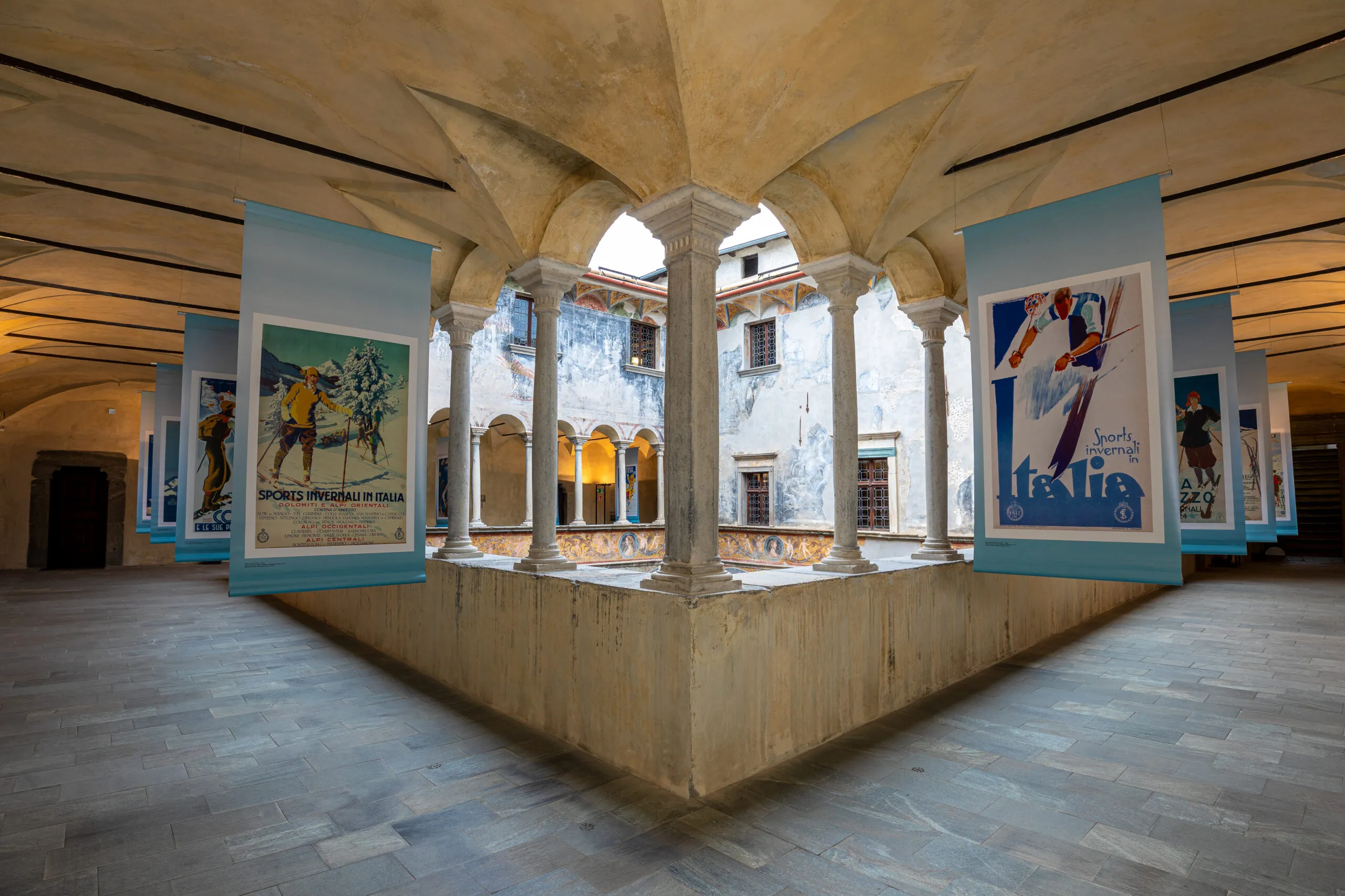 Nel loggiato del secondo piano, manifesti pubblicitari di località sciistiche raccontano l’affermarsi nel corso del Novecento di un nuovo immaginario legato alle montagne, che diventano luogo di divertimento e mondanità.